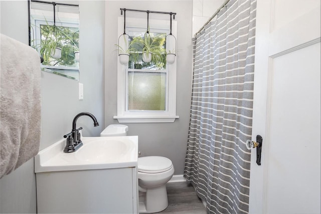 4892 N Mohawk Ave, Glendale, WI 53217 - full bath featuring vanity, toilet, wood finished floors, curtained shower, and baseboards