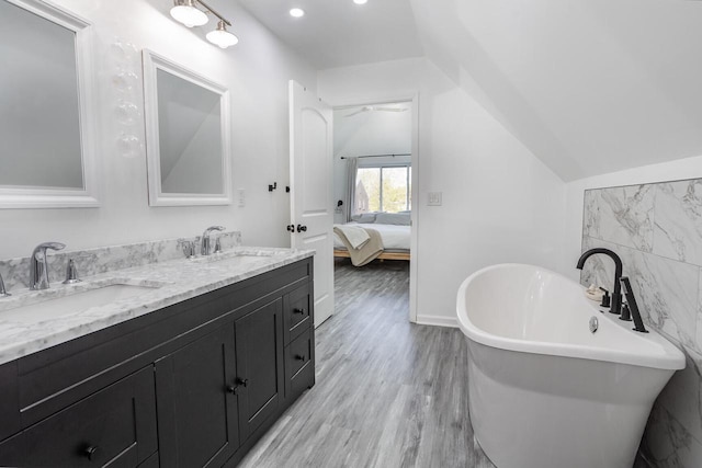 4892 N Mohawk Ave, Glendale, WI 53217 - ensuite bathroom with double vanity, a soaking tub, wood finished floors, recessed lighting, and vaulted ceiling
