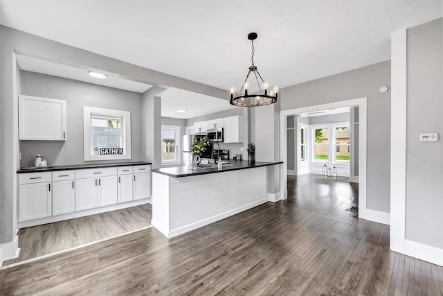 60 Brix St, Clintonville, WI 54929 - kitchen with stainless steel microwave, dark wood-type flooring, dark countertops, and healthy amount of natural light
