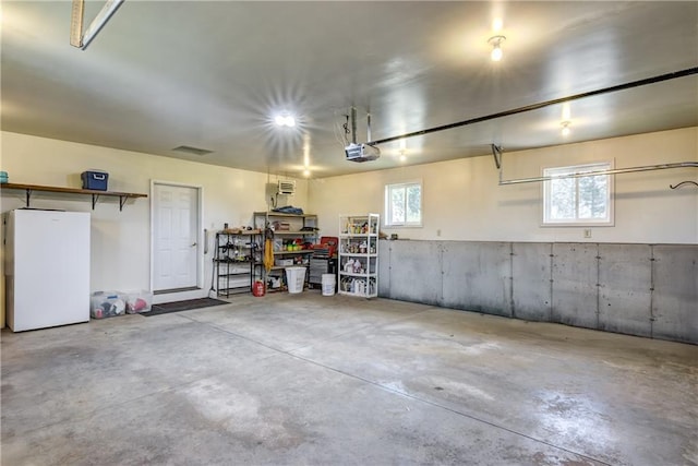 1816 186th St, Chippewa Falls, WI 54729 - garage featuring a garage door opener and freestanding refrigerator