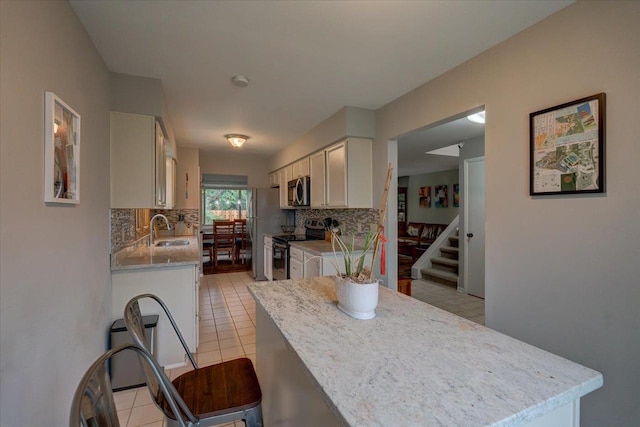 3514 Valley Ridge Rd, Middleton, WI 53562 - kitchen with stainless steel appliances, decorative backsplash, light tile patterned flooring, and a sink