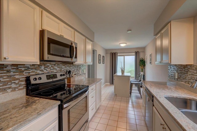 3514 Valley Ridge Rd, Middleton, WI 53562 - kitchen featuring appliances with stainless steel finishes, a sink, backsplash, light tile patterned floors, and light stone counters