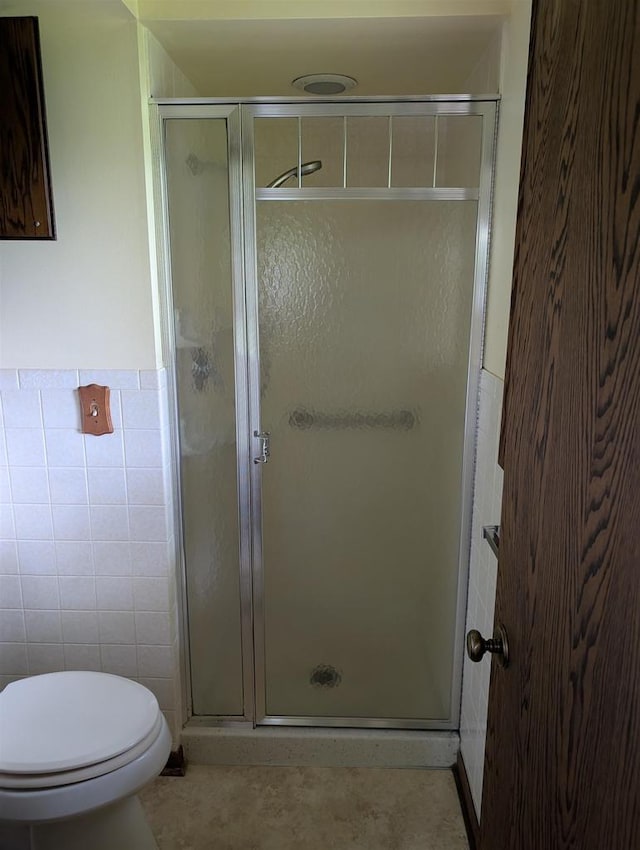 1741 Heuss Ave, Weston, WI 54476 - full bathroom featuring tile walls, a shower stall, toilet, tile patterned floors, and a wainscoted wall