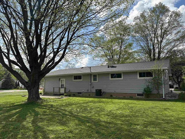 174 Mckinley Ave, Clintonville, WI 54929 - back of property with a lawn, a chimney, and central AC unit