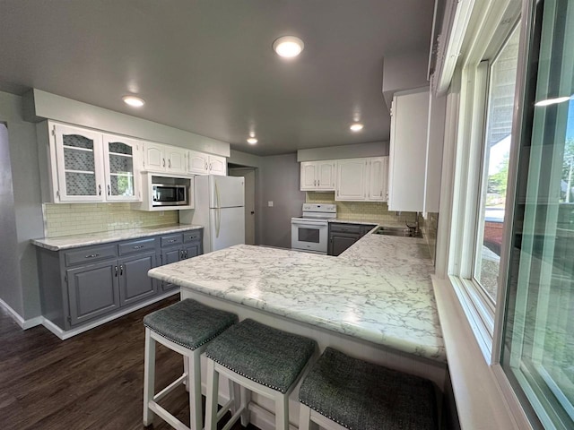 174 Mckinley Ave, Clintonville, WI 54929 - kitchen with white appliances, a sink, a peninsula, tasteful backsplash, and gray cabinets
