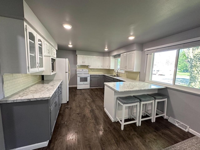 174 Mckinley Ave, Clintonville, WI 54929 - kitchen with white appliances, a sink, a peninsula, gray cabinetry, and recessed lighting