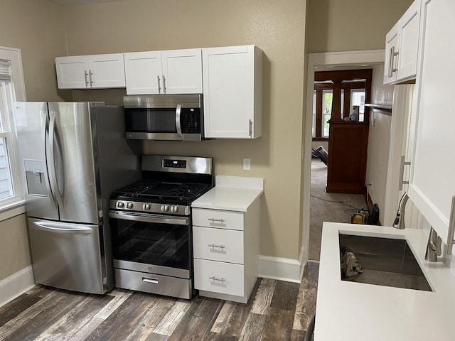 3122 W Madison St, Milwaukee, WI 53215 - kitchen with appliances with stainless steel finishes, baseboards, dark wood-type flooring, and white cabinetry