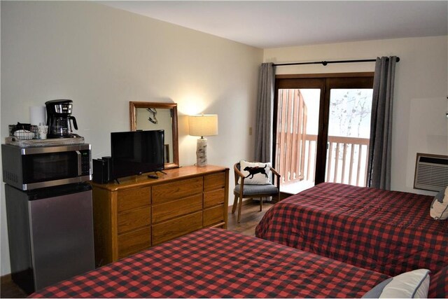 15326 W Birch Point Rd, Hayward, WI 54843 - bedroom with access to exterior, a wall unit AC, and wood finished floors