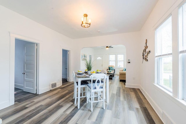 1516 Blake Ave, Racine, WI 53404 - dining room featuring arched walkways, wood finished floors, ceiling fan, baseboards, and a chandelier