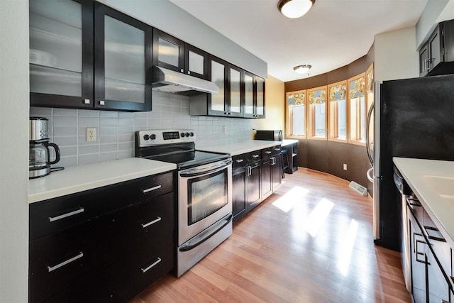 69 Ponwood Cir, Madison, WI 53717 - kitchen featuring stainless steel range with electric cooktop, under cabinet range hood, light wood-style floors, and backsplash