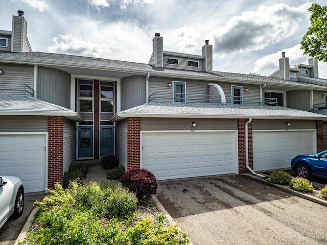 69 Ponwood Cir, Madison, WI 53717 - townhome / multi-family property featuring a chimney, driveway, brick siding, and a garage