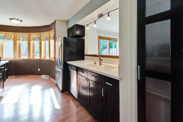 69 Ponwood Cir, Madison, WI 53717 - kitchen with dishwasher, light wood-style floors, a sink, light countertops, and rail lighting