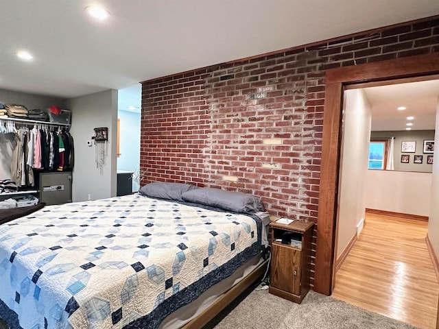 11691 County Road P, Bagley, WI 53801 - bedroom featuring brick wall, a closet, light wood finished floors, recessed lighting, and baseboards