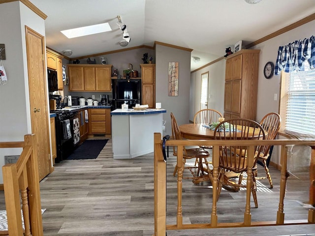 33150 Donna Dr, Prairie Du Chien, WI 53821 - dining room with a skylight, crown molding, light wood-style flooring, lofted ceiling, and healthy amount of natural light