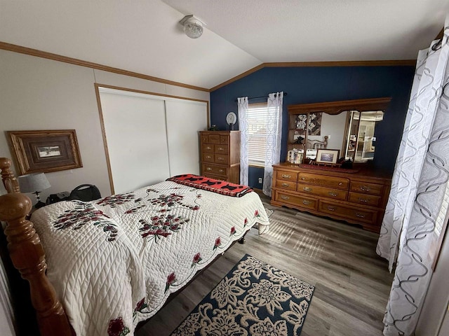 33150 Donna Dr, Prairie Du Chien, WI 53821 - bedroom with vaulted ceiling, a closet, wood finished floors, and crown molding
