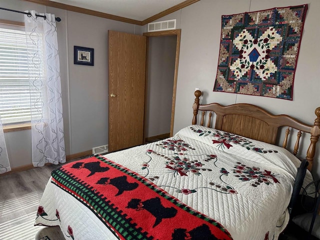33150 Donna Dr, Prairie Du Chien, WI 53821 - bedroom featuring wood finished floors, crown molding, and baseboards