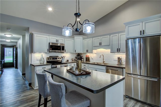5631 Green Park Dr, Eau Claire, WI 54703 - kitchen with appliances with stainless steel finishes, a sink, dark countertops, backsplash, and a kitchen breakfast bar