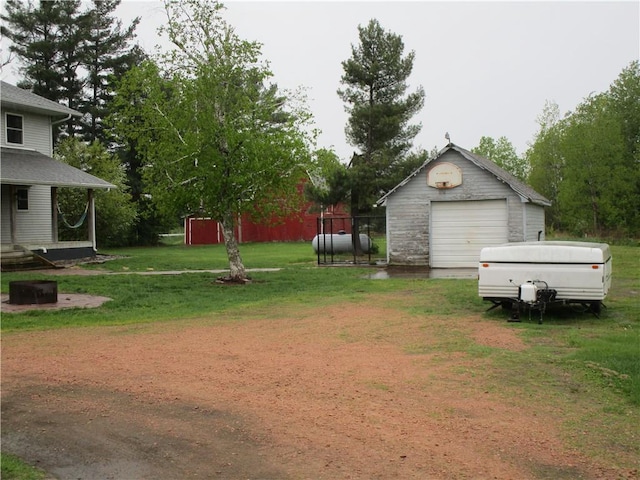 W12058 US Highway 8, Bruce, WI 54819 - view of green lawn featuring a garage, an outbuilding, and driveway