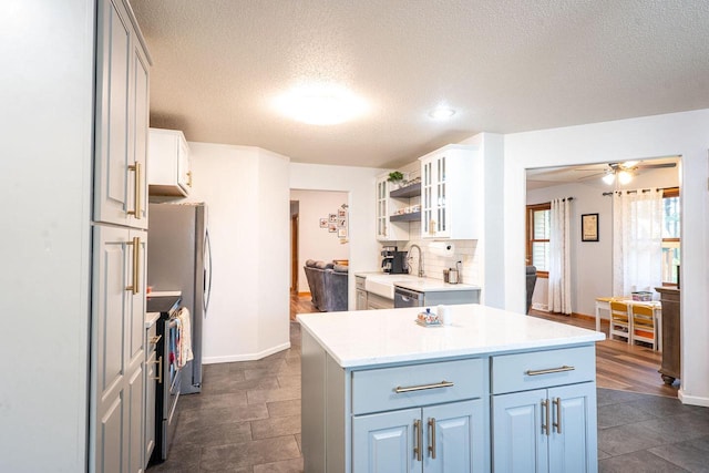 24301 Dexter Ave, Tomah, WI 54660 - kitchen with stainless steel electric range oven, open shelves, a textured ceiling, ceiling fan, and light countertops
