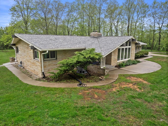 8445 S 44th St, Franklin, WI 53132 - view of front facade featuring stone siding, roof with shingles, a chimney, and a front yard