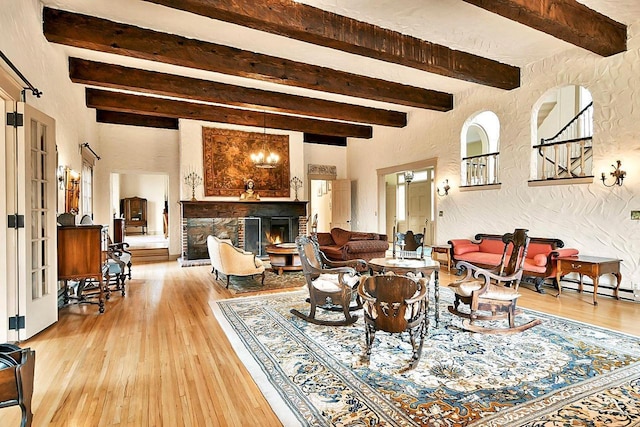 933 Nebraska Row, La Pointe, WI 54850 - living room featuring beam ceiling, light wood-style flooring, a textured wall, and a warm lit fireplace