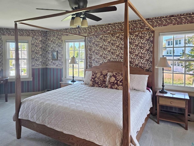 933 Nebraska Row, La Pointe, WI 54850 - carpeted bedroom with wallpapered walls, multiple windows, a wainscoted wall, and a ceiling fan