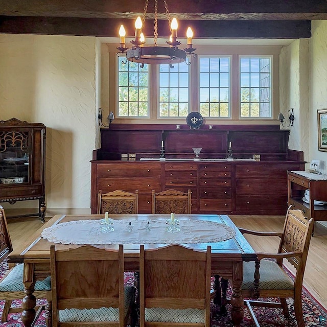 933 Nebraska Row, La Pointe, WI 54850 - dining space featuring light wood-style flooring, a chandelier, a textured wall, and beam ceiling