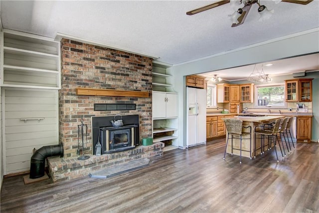 12272 Ewig Rd, Hayward, WI 54843 - kitchen with white fridge with ice dispenser, a wood stove, a kitchen bar, dark wood-type flooring, and a textured ceiling