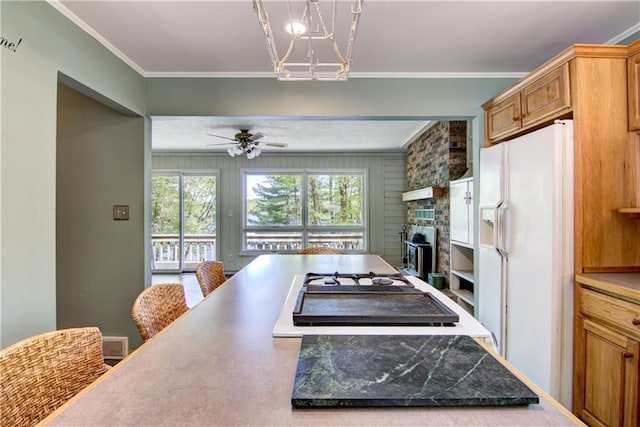 12272 Ewig Rd, Hayward, WI 54843 - kitchen with white appliances, a chandelier, ceiling fan, a stone fireplace, and crown molding