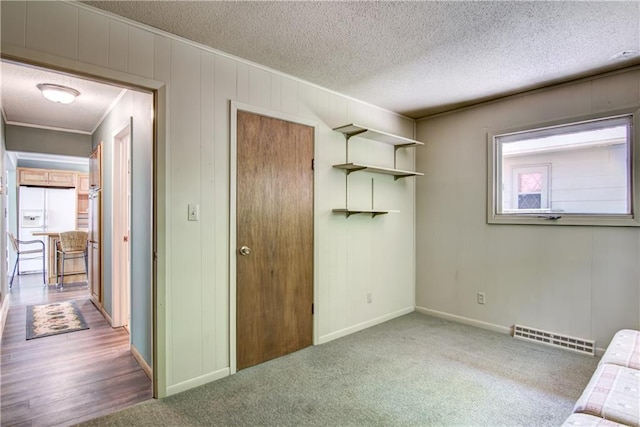 12272 Ewig Rd, Hayward, WI 54843 - unfurnished bedroom featuring a textured ceiling, baseboards, a closet, carpet floors, and white fridge with ice dispenser