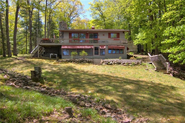 12272 Ewig Rd, Hayward, WI 54843 - rear view of property with stairway, a wooden deck, a chimney, and a yard