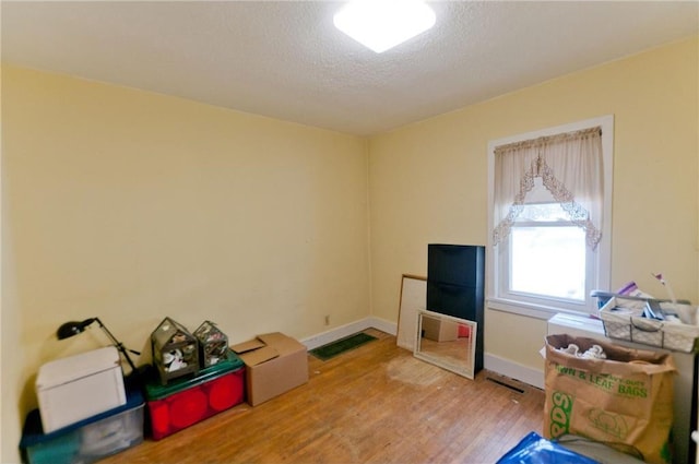915 W Knapp St, Rice Lake, WI 54868 - miscellaneous room featuring wood finished floors, a textured ceiling, and baseboards