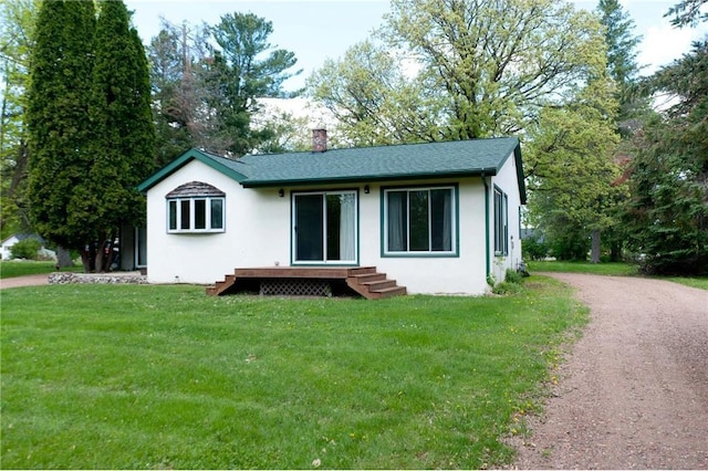 915 W Knapp St, Rice Lake, WI 54868 - view of front of home with a front yard, a chimney, stucco siding, and dirt driveway