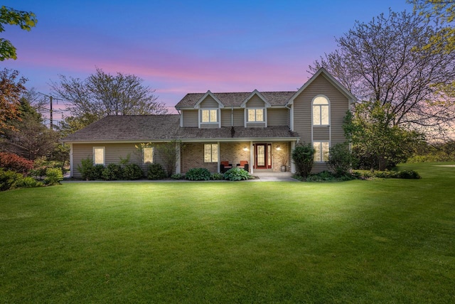 11616 N Lantern Ln, Mequon, WI 53092 - traditional-style house featuring a lawn, covered porch, and brick siding