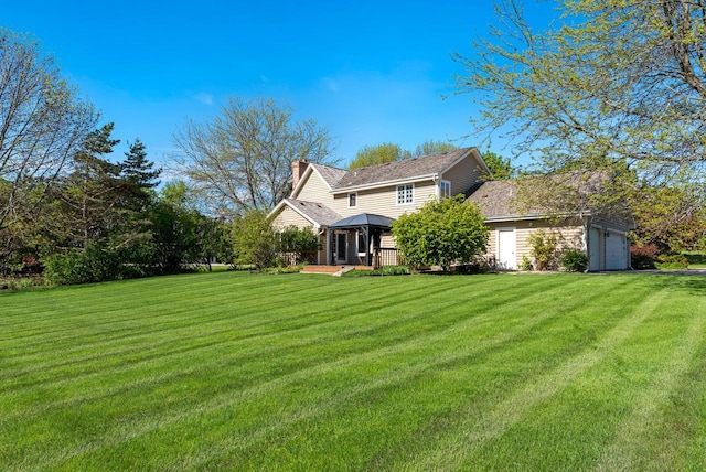 11616 N Lantern Ln, Mequon, WI 53092 - rear view of house with a gazebo, a chimney, a lawn, and an attached garage