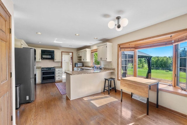 11616 N Lantern Ln, Mequon, WI 53092 - kitchen with stainless steel appliances, a peninsula, wood finished floors, baseboards, and recessed lighting