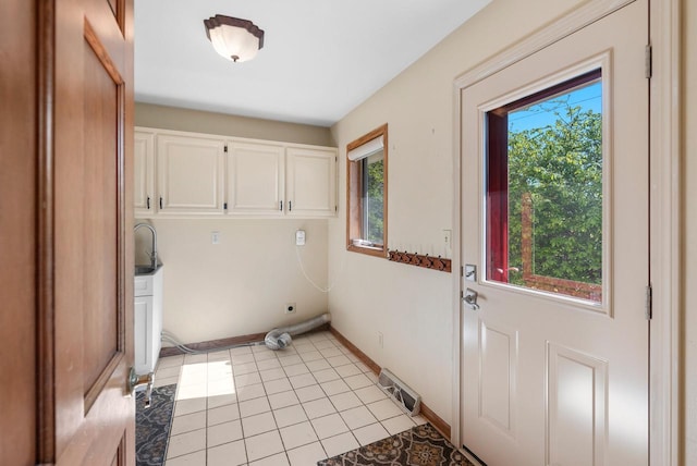 11616 N Lantern Ln, Mequon, WI 53092 - laundry room featuring cabinet space, healthy amount of natural light, light tile patterned floors, and baseboards