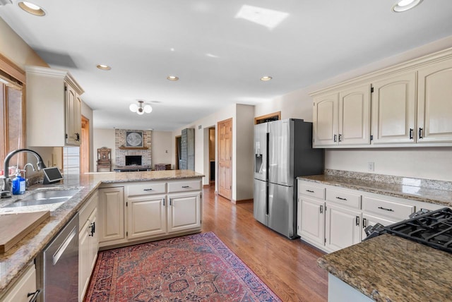 11616 N Lantern Ln, Mequon, WI 53092 - kitchen with a sink, stainless steel appliances, a peninsula, light wood finished floors, and recessed lighting
