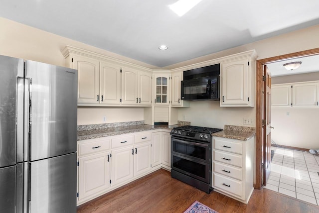 11616 N Lantern Ln, Mequon, WI 53092 - kitchen with stainless steel appliances, light stone counters, dark wood-style floors, and recessed lighting