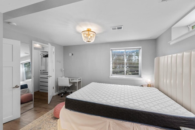 11616 N Lantern Ln, Mequon, WI 53092 - bedroom with multiple windows, wood finished floors, a chandelier, and a walk in closet