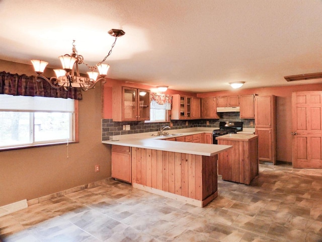 N11475 Post Lake Dr, Elcho, WI 54428 - kitchen with black range with gas stovetop, a sink, light countertops, a peninsula, and under cabinet range hood