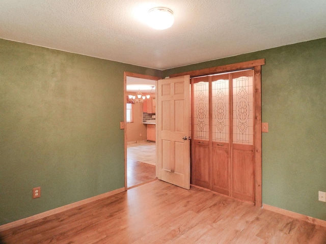 N11475 Post Lake Dr, Elcho, WI 54428 - unfurnished bedroom featuring light wood-style flooring, a chandelier, and baseboards