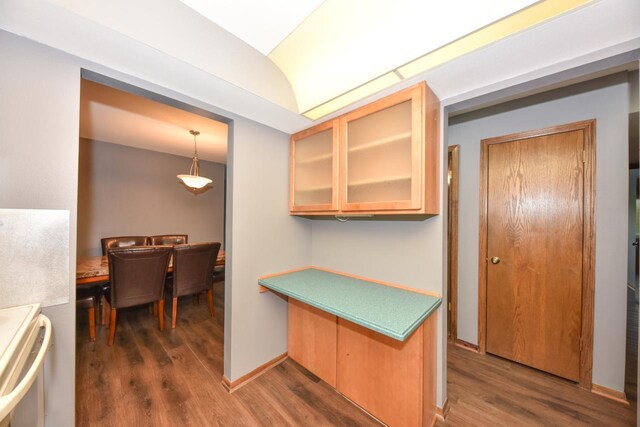 6575 N Green Bay Ave Unit 211, Glendale, WI 53209 - kitchen with dark wood finished floors, stove, glass insert cabinets, lofted ceiling, and baseboards