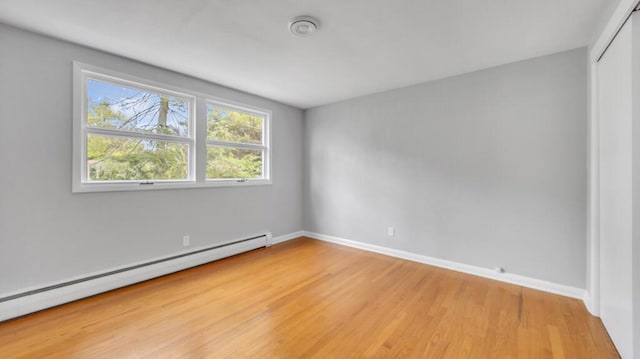 1007 Forest Hill Dr, Green Bay, WI 54311 - empty room featuring a baseboard radiator, light wood-style floors, and baseboards