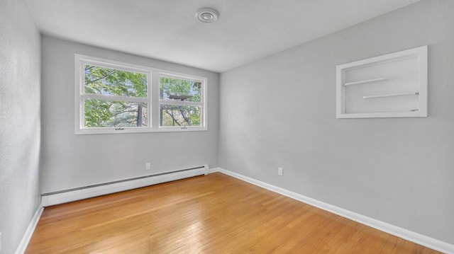 1007 Forest Hill Dr, Green Bay, WI 54311 - spare room with baseboard heating, wood finished floors, and baseboards
