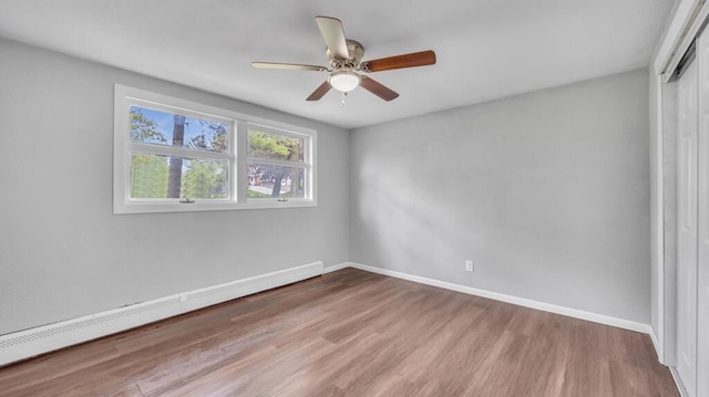 1007 Forest Hill Dr, Green Bay, WI 54311 - empty room featuring a baseboard radiator, wood finished floors, a ceiling fan, and baseboards