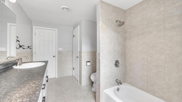 1007 Forest Hill Dr, Green Bay, WI 54311 - bathroom featuring tile walls, vanity, toilet, tile patterned flooring, and washtub / shower combination