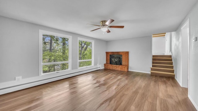 1007 Forest Hill Dr, Green Bay, WI 54311 - unfurnished living room with wood finished floors, a baseboard radiator, a ceiling fan, stairway, and baseboards