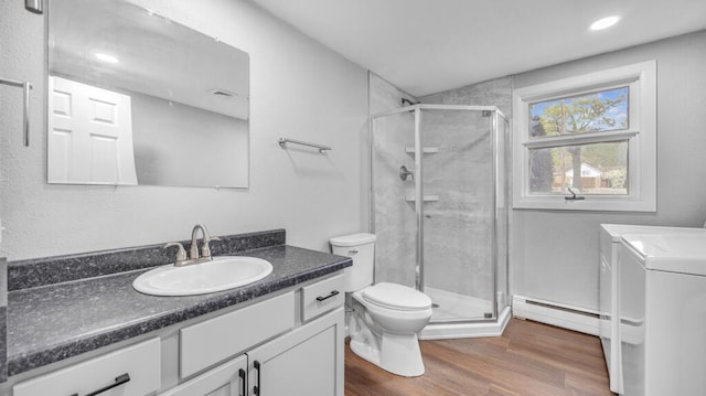 1007 Forest Hill Dr, Green Bay, WI 54311 - bathroom with independent washer and dryer, a baseboard heating unit, toilet, vanity, and a stall shower