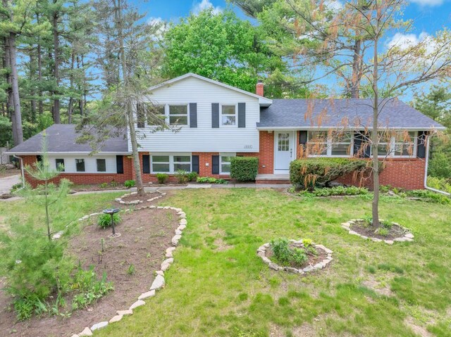 1007 Forest Hill Dr, Green Bay, WI 54311 - split level home featuring brick siding, a chimney, and a front lawn
